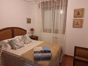 Un dormitorio con una cama con dos toallas encima. en Apartamento Faro de Tapia, en Tapia de Casariego