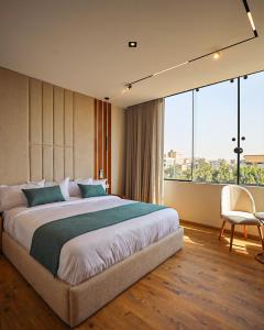 a bedroom with a large bed and a large window at Palacio Pyramids Hotel in Cairo