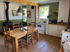 eine Küche mit Holztisch und ein Esszimmer in der Unterkunft La maison des Coteaux in LʼAnse-Saint-Jean