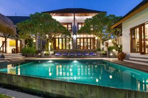 a swimming pool in front of a house at Jabunami Estate in Canggu