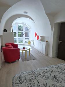 een woonkamer met een rode bank en een tafel bij Apartmán U Zlaté Hvězdy in Benešov