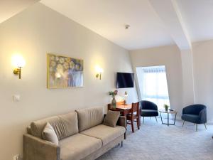 a living room with a couch and a table at Hotel Piast Wrocław Centrum in Wrocław