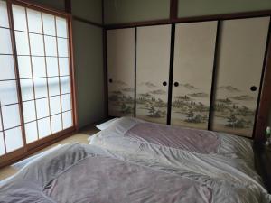 a bedroom with a bed and two windows at 8 minutes by walk to Nikko Station Mitsuba House in Nikko +19 photos