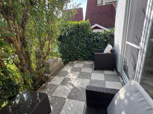 OberteuringenBusiness & Monteur Apartment - Modern Style & Comfort - Bodensee-Oberschwaben的一个带两把椅子的庭院和 ⁇ 格地板