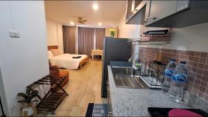 een keuken met een wastafel en een woonkamer met een bed bij Sport villa Huahin, Room 225, Studio Queen Bed pool view and Kitchenette, 2nd Floor in Hua Hin