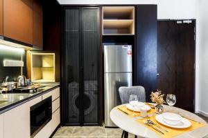 a kitchen with a table and a refrigerator at Scarletz Service Suites KLCC in Kuala Lumpur
