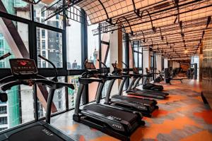 a row of treadmills in a gym with large windows at Scarletz Service Suites KLCC in Kuala Lumpur
