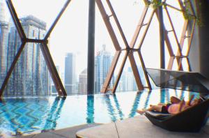 a hotel swimming pool with a view of a city at Scarletz Service Suites KLCC in Kuala Lumpur