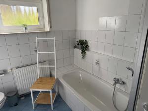OberteuringenBusiness & Monteur Apartment - Modern Style & Comfort - Bodensee-Oberschwaben的带浴缸的浴室和桌子 更多24张照片