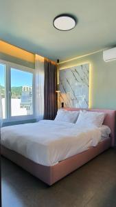 a bedroom with a large bed with a large window at Despoina Luxury Suites Xanthi in Xanthi