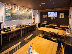a restaurant with wooden tables and chairs and a television at APA Hotel Koriyama Ekimae in Koriyama