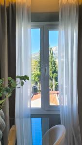 a window with white curtains in a room at Despoina Luxury Suites Xanthi in Xanthi +32 photos