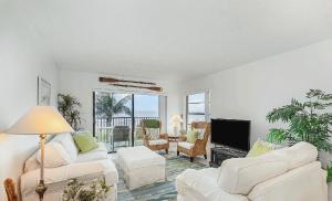 Una sala de estar con muebles blancos y un televisor de pantalla plana. en Oceanview Two Bedroom Condo with Beach Access, en Cocoa Beach 13 fotos más