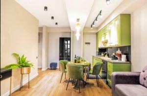 a kitchen and living room with green cabinets and a table and chairs at Green House Mindeli in Tbilisi City