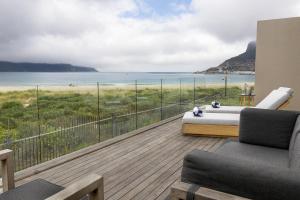 a balcony with a bed and a view of the beach at Beachfront @ Beach Club in Cape Town