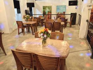 a wooden table with a vase of flowers on it at GT Homes Peradeniya in Peradeniya
