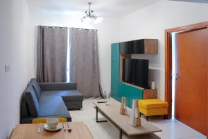 a living room with a couch and a tv at Khayali Marina Holiday Homes Dubai Marina JBR in Dubai
