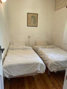two twin beds in a room with wood floors at Casa nel Bosco in Trento