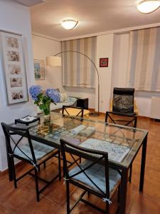 Una sala de estar con una mesa de cristal y sillas. en Apartamento Faro de Tapia, en Tapia de Casariego