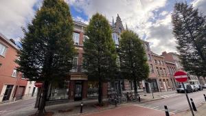 a building on a city street with trees and a stop sign at Appartment in Lier City Center in Mellet +13 photos