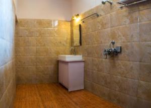 a bathroom with a sink and a shower at Kasar Rainbow Yoga Retreat in Hawālbāgh +39 photos