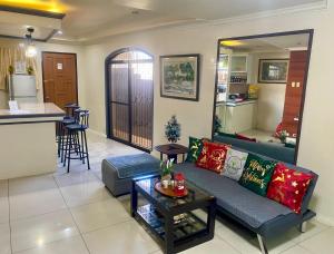 a living room with a couch and a kitchen at Spacious Modern 4BR Home with 24hr Security and Parking in Cagayan de Oro