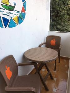 two chairs and a wooden table and a table and chairs at Gana kato in Aswan