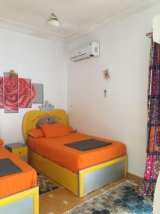a bedroom with two beds with orange bedding at Gana kato in Aswan