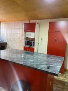 a kitchen with a counter and a microwave and red cabinets at House in Molina in Molina +2 photos