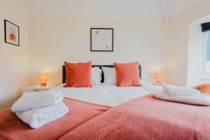 a bedroom with a bed with orange and white pillows at Large 5BR 3BA Home Leamington Spa Driveway Parking WI-FI in Leamington Spa