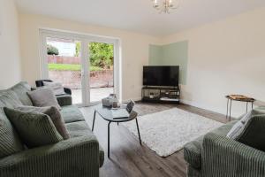 a living room with two couches and a tv at Large 5BR 3BA Home Leamington Spa Driveway Parking WI-FI in Leamington Spa