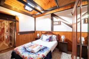 a bedroom with a bed in a room with wooden walls at Refugio con encanto en la Gomera con vistas a las montañas in Arure
