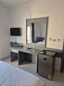Habitación con escritorio, espejo y cama. en Elixir Hotel Hurghada, en Hurghada