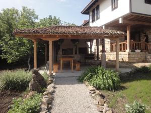 a wooden pergola on the side of a house at Mutafova Guest House in Veliki Preslav