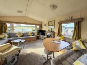 a living room with a couch and a table at Brilliant 6 Berth Caravan With Decking At Heacham Beach Park Ref 21031A in Heacham