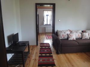 a living room with a couch and a television at Mutafova Guest House in Veliki Preslav