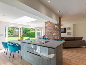 a kitchen and living room with a large island with blue chairs at Sea Breezes in Anderby