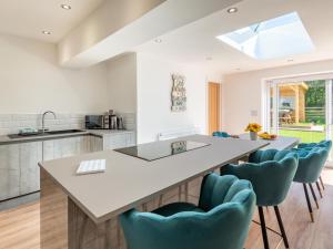 a kitchen with a large white table and blue chairs at Sea Breezes in Anderby +16 photos