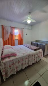 una camera da letto con un letto e un ventilatore a soffitto di Sitio Balneario do Sossego a Rolante