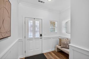 a white hallway with a door and a chair at Discovery Haven townhouse in Monrovia +35 photos