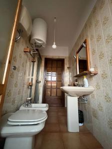 a bathroom with a toilet and a sink and a mirror at alta marea sardegna in Portoscuso