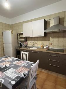 a kitchen with a table with chairs and a refrigerator at alta marea sardegna in Portoscuso