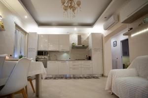 a kitchen with white cabinets and a chandelier at Nuova Fiera di Roma in Ponte Galeria +37 photos