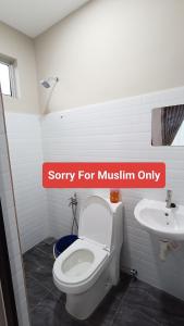Un baño con un inodoro blanco y un lavabo. en The Junid Hauz Muar, en Muar