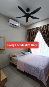 Un dormitorio con una cama y un ventilador de techo. en The Junid Hauz Muar, en Muar