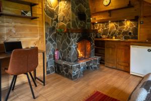 a kitchen with a stone fireplace and a table and chair at Camp Bilyi Slon in Dzembronya
