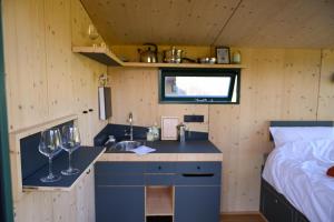 a kitchen with a sink and two wine glasses at Green&Tiny Spot Rehburg an der Schafweide - Sleep Space 3 in Bad Rehburg