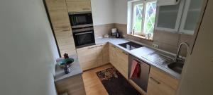 eine kleine Küche mit Spüle und Herd in der Unterkunft Sweet forest cottage near Munich in Oberhaching