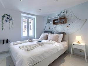 Una habitación blanca con una cama grande con sábanas blancas. en Apartment Ambient by Interhome, en Rovinj