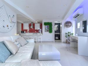 Una sala de estar con un sofá blanco y una cocina. en Apartment Ambient by Interhome, en Rovinj